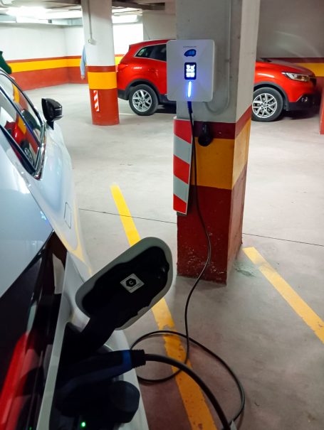 Estación de carga eléctrica para vehículos en un aparcamiento subterráneo.