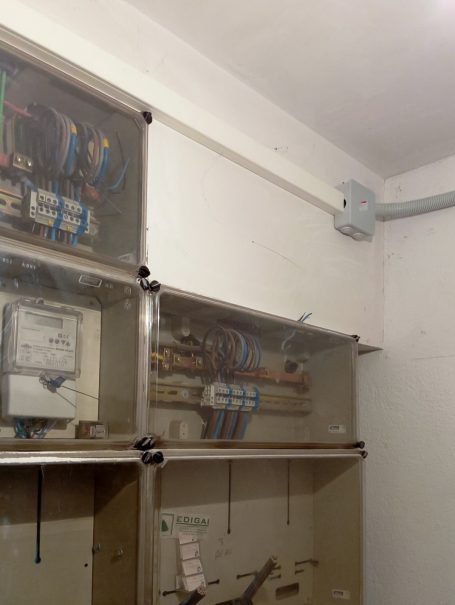 Cajas eléctricas en una pared con cables conectados y medidores visibles.