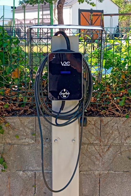 Punto de carga para vehículos eléctricos con cable enrollado.